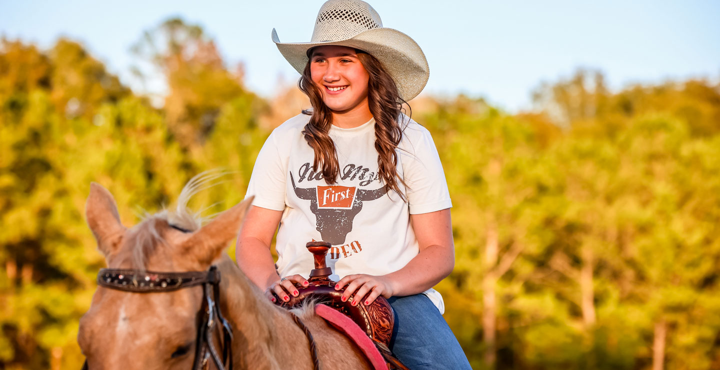 Ella Nipper sitting on her horse smiling.